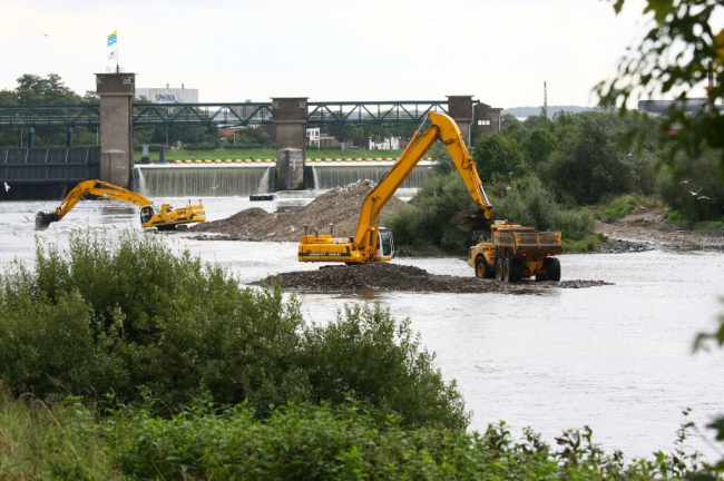 Van Reen van Beek, oud-medewerker van RWS, vernam ik dat RWS de stortebedden achter de stuw gaat vernieuwen. Daarvoor zullen materieel en materialen achter de stuw moeten komen. Onlangs is gestart met de aanleg van een eerste dam waarop een werkweg zal worden aangelegd. Twee Caterpillar rupskranen en twee dumpers zijn daarmee bezig. Medio november moet het werk gereed zijn. Met dank aan Reen van Beek. 