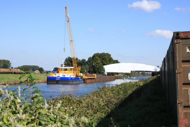 De ingepakte brug van Bunde over het Julianakanaal waaraan onderhouds-werkzaamheden werden gepleegd. Rechts de geluidswal van zeecontainers.
De damwand in het Julianakanaal zal nadat er een opening is gemaakt in de dijk weer worden weggenomen zodat schepen in en uit kunnen varen om kiezel af te voeren. De ingepakte brug van Bunde over het Julianakanaal waaraan onderhouds-werkzaamheden werden gepleegd. Rechts de geluidswal van zeecontainers.
De damwand in het Julianakanaal zal nadat er een opening is gemaakt in de dijk weer worden weggenomen zodat schepen in en uit kunnen varen om kiezel af te voeren.