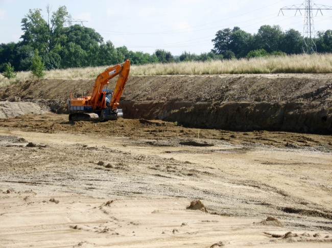 Werkzaamheden aan de oostzijde van het verwerkingsbekken. Op de achtergrond de oude weg naar Voulwammes en de kanaaldijk. Werkzaamheden aan de oostzijde van het verwerkingsbekken. Op de achtergrond de oude weg naar Voulwammes en de kanaaldijk.
