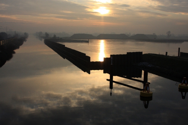 De ondergaande zon spiegelt in het ijs dat zich op de laatste dag van 2008 alsnog heeft gevormd op het water in het verwerkingsbekken. Over een week zal men starten met het verwijderen van de damwand in het Julianakanaal.