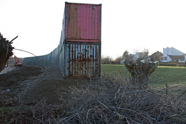 Zicht vanaf de kade bij Op de Warrey. Rechts de woningen van Op de Hoogmaas. Links van de deze containers zal nog een werkweg worden aangelegd voor de aanvoer van toutvenant vanaf de locatie Borgharen. Zicht vanaf de kade bij Op de Warrey. Rechts de woningen van Op de Hoogmaas. Links van de deze containers zal nog een werkweg worden aangelegd voor de aanvoer van toutvenant vanaf de locatie Borgharen.