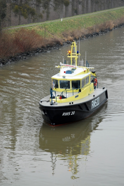 Een boot van RWS met zwaailicht ging de bagger voor op zijn tocht door het Julianakanaal.