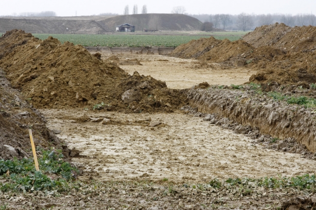 De archeologische opgravingen zijn nog steeds in volle gang. Op de achtergrond het gronddepot met daarvoor de loods van Richard Kerkhofs. De archeologische opgravingen zijn nog steeds in volle gang. Op de achtergrond het gronddepot met daarvoor de loods van Richard Kerkhofs.