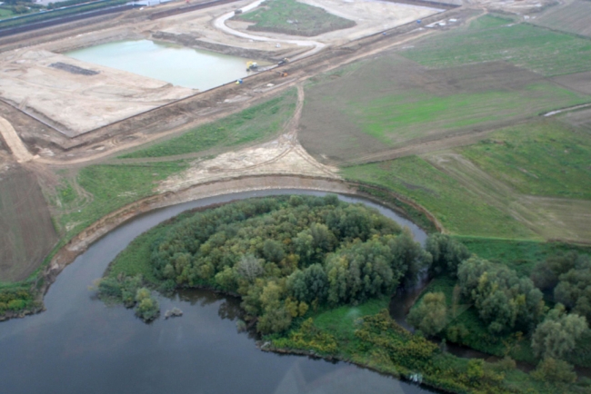 De bocht in de Geul bij de monding in de Maas. Dit gedeelte van de Geul zal bij de ontgrinding worden gespaard. Op de achtergrond het verwerkingsbekken. De bocht in de Geul bij de monding in de Maas. Dit gedeelte van de Geul zal bij de ontgrinding worden gespaard. Op de achtergrond het verwerkingsbekken.
