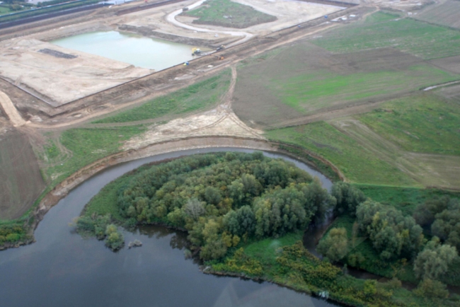 De bocht in de Geul bij de monding in de Maas. Dit gedeelte van de Geul zal bij de ontgrinding worden gespaard. Op de achtergrond het verwerkingsbekken.