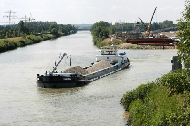 Binnenvaartschip Carina verlaat het verwerkingsbekken, geladen met grind dat even daarvoor door het baggerschip Merwede 28 uit het verwerkingsbekken is opgediept. Het binnenvaartschip Carina is 69,98m lang, 8,20m breed, heeft een diepgang van 2,71m en kan 927 ton laden. Het casco van het schip is in 2000 in Rusland gebouwd. Binnenvaartschip Carina verlaat het verwerkingsbekken, geladen met grind dat even daarvoor door het baggerschip Merwede 28 uit het verwerkingsbekken is opgediept. Het binnenvaartschip Carina is 69,98m lang, 8,20m breed, heeft een diepgang van 2,71m en kan 927 ton laden. Het casco van het schip is in 2000 in Rusland gebouwd.