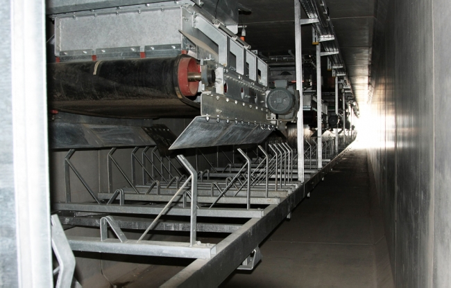 Lopende band in de tunnel die het grint van de terp verder vervoert naar de grindverwerkingsinstallatie voor verdere sortering. De tunnel is ook toegankelijk voor medewerkers in verband met onderhoud.