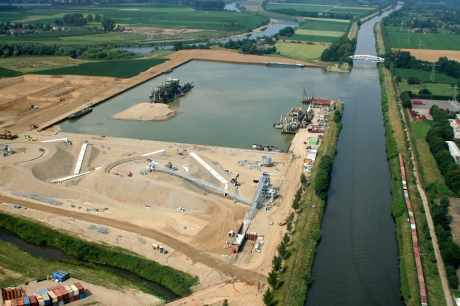 Luchtfoto van het verwerkingsbekken. Op de voorgrond het grintdepot en linksboven in het verwerkingsbekken de Merwede 28, rechts het Julianakanaal met de brug van Bunde. Helemaal bovenaan links ziet u de bocht van de Maas ter hoogte van Herbricht. Luchtfoto van het verwerkingsbekken. Op de voorgrond het grintdepot en linksboven in het verwerkingsbekken de Merwede 28, rechts het Julianakanaal met de brug van Bunde. Helemaal bovenaan links ziet u de bocht van de Maas ter hoogte van Herbricht.