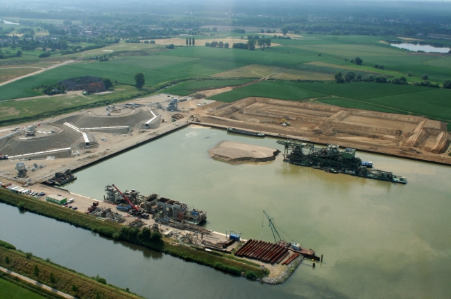 Achter het verwerkingsbekken ziet u de bezinkbassins. Het water van het verwerkingsbekken is al verkleurd door het slib dat vrijkomt bij het wassen van het grind en zal naar de bezinkbasins worden gepompt om gezuiverd te worden. Achter het verwerkingsbekken ziet u de bezinkbassins. Het water van het verwerkingsbekken is al verkleurd door het slib dat vrijkomt bij het wassen van het grind en zal naar de bezinkbasins worden gepompt om gezuiverd te worden.