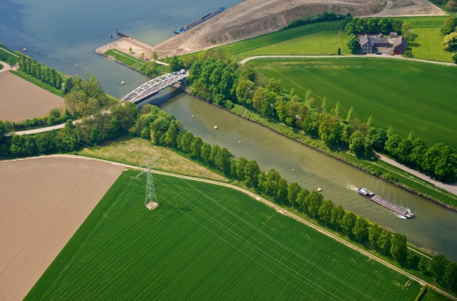 De brug over het Julianakanaal bij Bunde, met de geluidswal achter Voulwammes en de opening in de dijk van het Julianakanaal. De brug over het Julianakanaal bij Bunde, met de geluidswal achter Voulwammes en de opening in de dijk van het Julianakanaal.