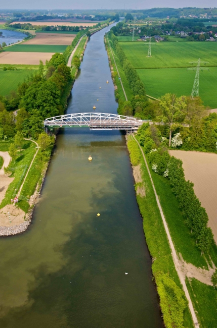 Het Julianakanaal met de brug van Bunde. Hier is duidelijk de verkleuring van het water te zien door modder die vrijkomt bij het wassen van het grind.