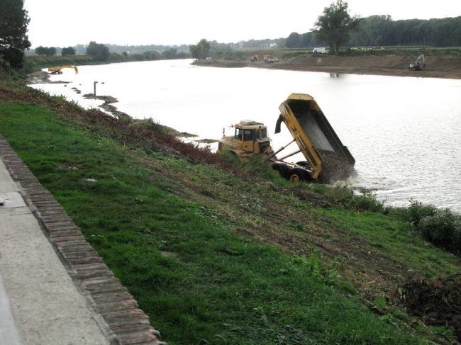 Plaatselijk is de Maas in het verleden wat dieper uitgebaggerd en daarom moet voor de aanleg van de werkweg de kiezel wat verderop in de Maas worden gewonnen en per dumper naar de diepere plekken worden vervoerd. Plaatselijk is de Maas in het verleden wat dieper uitgebaggerd en daarom moet voor de aanleg van de werkweg de kiezel wat verderop in de Maas worden gewonnen en per dumper naar de diepere plekken worden vervoerd.