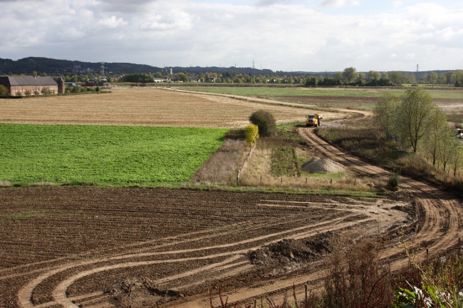 Bij Ankersmit, gelegen aan het Julianakanaal, worden de grote breukstenen met schepen aangevoerd om de Maasoever te Itteren te verstevigen. Met dumpers worden de stenen naar de Maas vervoerd, via een extra werkweg omdat aanvoer door de dorpskern te veel overlast met zich meebrengt. Links op de foto Kasteelhoeve Hartelstein. Bij Ankersmit, gelegen aan het Julianakanaal, worden de grote breukstenen met schepen aangevoerd om de Maasoever te Itteren te verstevigen. Met dumpers worden de stenen naar de Maas vervoerd, via een extra werkweg omdat aanvoer door de dorpskern te veel overlast met zich meebrengt. Links op de foto Kasteelhoeve Hartelstein.