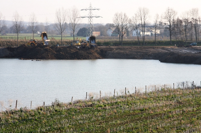 Het eerder gegraven gat waar de kiezel is uitgehaald wordt weer opgevuld met de afgegraven dekgrond. Het opgevulde gebied komt straks 2m lager te liggen dan de omgeving. Het eerder gegraven gat waar de kiezel is uitgehaald wordt weer opgevuld met de afgegraven dekgrond. Het opgevulde gebied komt straks 2m lager te liggen dan de omgeving.