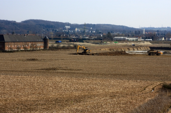 Foto vanaf het uitkijkpunt genomen met op de voorgrond het afgraven van de dekgrond. Links Kasteelboerderij Hoeve Hartelstein.