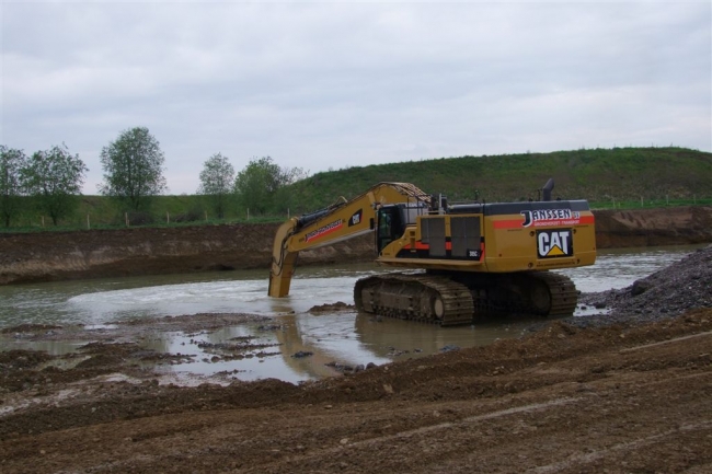 De graafmachine zit nu op een diepte van 9 meter. Op de volgende foto's staat dat duidelijk gemarkeerd op de arm. De gemiddelde diepte is 11 meter. Op sommige plaatsen ligt het grind tot 15 meter. Regelmatig wordt met duikers gecontroleerd of overal alle grind weg is.