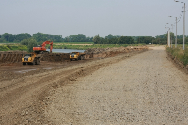 Rechts op de foto de pas aangelegde nieuwe weg, die nog afgewerkt moet worden, naar Herbricht. Links zie je de afgraving van de bocht waardoor de Maas ook hier meer ruimte krijgt. Achterdoor zie je de Maas stromen. 