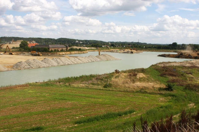 Aan de zuidzijde van Kasteelhoeve Hartelstein is de kiezel al geheel weggehaald. Rechts op de foto zie je dat het volstorten van de dekgrondberging al ver is gevorderd. Aan de zuidzijde van Kasteelhoeve Hartelstein is de kiezel al geheel weggehaald. Rechts op de foto zie je dat het volstorten van de dekgrondberging al ver is gevorderd.