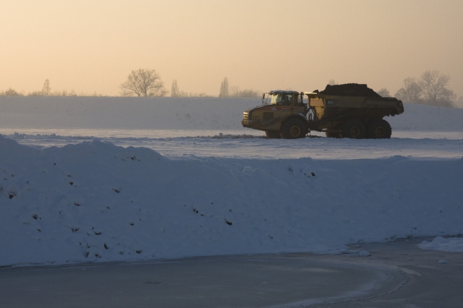 Doordat de grintverwerkingsinstallatie door de vorst stil ligt wordt nu alleen nog maar met enkele dumpers afgegraven dekgrond vanuit de stroomgeulverbreding hier aangevoerd. Doordat de grintverwerkingsinstallatie door de vorst stil ligt wordt nu alleen nog maar met enkele dumpers afgegraven dekgrond vanuit de stroomgeulverbreding hier aangevoerd.