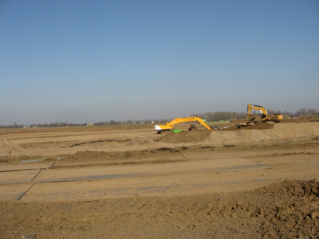 Op de achtergrond de graafmachine die aan de noordelijke dekgrondberging bezig is.