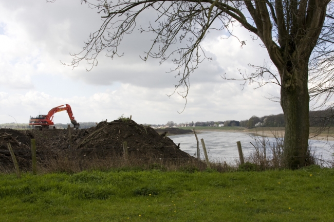 Zoals je ziet is de graafmachine al tot aan de bomenrij, die het laatste stukje groen achter de kapel in Itteren omzoomd, gevorderd. 