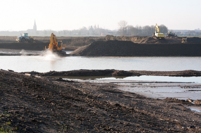 Begin januari 2013 was het water in de Maas zover gezakt dat de werkzaamheden weer konden worden hervat. Op de achtergrond de kerk van Borgharen. Begin januari 2013 was het water in de Maas zover gezakt dat de werkzaamheden weer konden worden hervat. Op de achtergrond de kerk van Borgharen.
