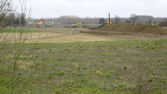 Zicht vanaf de kade op de nieuwe recreatievijver in aanleg.  