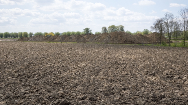 Duidelijk steekt het restant van de nog af te graven dekgrond boven het maaiveld uit. Dit is het gedeelte aan de westkant vlak bij de kade. Duidelijk steekt het restant van de nog af te graven dekgrond boven het maaiveld uit. Dit is het gedeelte aan de westkant vlak bij de kade.