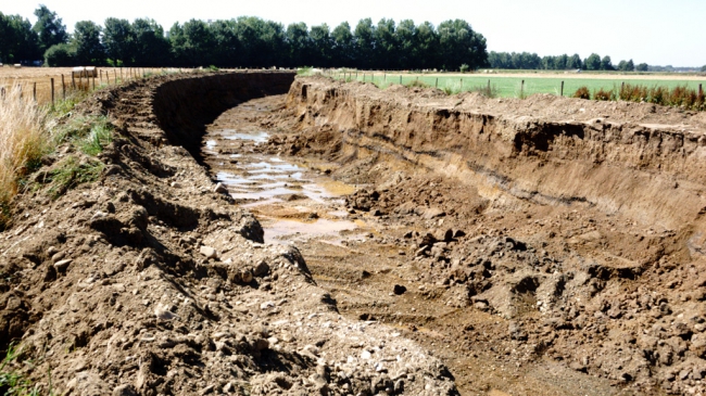 Op de bodem van de werkweg komt al grondwater te voorschijn , zo diep wordt gegraven. Grond om weer aan te vullen hebben ze toch zat. 