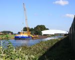 De ingepakte brug van Bunde over het Julianakanaal waaraan onderhouds-werkzaamheden werden gepleegd. Rechts de geluidswal van zeecontainers.
De damwand in het Julianakanaal zal nadat er een opening is gemaakt in de dijk weer worden weggenomen zodat schepen in en uit kunnen varen om kiezel af te voeren. (14-9-2008 - Jan Dolmans)