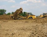 Hier lost een knikgestuurde dumptruck zijn lading. Afhankelijk van het type dumper kan tussen de 25 en 40 ton geladen worden. Hier is een CAT 735 aan het werk met een laadvermogen van 32,7 ton. (23-5-2008 - Han Hamakers)