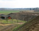 Het gronddepot is al verder naar het zuiden doorgetrokken en zal gaan gaan aansluiten op de geluidswal nabij de kade van Op de Hoogmaas. Links de loods van Richard Kerkhofs die binnenkort zal worden afgebroken. (7-3-2009 - Jan Dolmans)