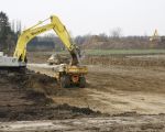 De kiezel zit hier minder diep zodat er minder hoeft te worden afgegraven. Per dag wordt zo'n 2500 tot 3000 m3 grond verzet. Aan de rechterkant ziet u het gronddepot waar de afgegraven grond wordt opgeslagen. Het gronddepot doet tevens dienst als geluidswal. (13-3-2009 - Jan Dolmans)