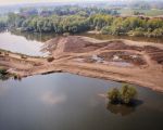 Vanuit de helicopter genomen foto van Hochter Bampd. Bij een waterafvoer van meer dan 250 m3 water in de Maas, staat het afgegraven gedeelte van de oever al onder water. In het midden van de foto ziet u de gedeeltelijk opgevulde grindplas met grond die vrijgekomen is bij de oeververlaging. (30-4-2009 - n.v.t.)