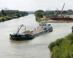 Binnenvaartschip Carina verlaat het verwerkingsbekken, geladen met grind dat even daarvoor door het baggerschip Merwede 28 uit het verwerkingsbekken is opgediept. Het binnenvaartschip Carina is 69,98m lang, 8,20m breed, heeft een diepgang van 2,71m en kan 927 ton laden. Het casco van het schip is in 2000 in Rusland gebouwd. (17-6-2009 - Jan Dolmans)