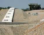 De betonnen tunnel voor de afvoer van de kiezel. De tunnels worden straks volledig bedolven onder de kiezel. Via de vulopeningen bovenop de tunnel, zakt de kiezel de tunnel in waar de lopende band hem verder vervoert richting de grindverwerkingsinstallatie. (25-6-2009 - Jan Dolmans)