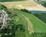 De rij van zeecontainers als geluidsscherm achter de huizen van Op de Hoogmaas vanuit de lucht gezien. (29-6-2009 - Waterschap Roer en Overmaas)