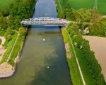 Het Julianakanaal met de brug van Bunde. Hier is duidelijk de verkleuring van het water te zien door modder die vrijkomt bij het wassen van het grind. (30-4-2009 - Bron: ing. Hans Brinkhof)