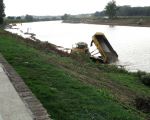 Plaatselijk is de Maas in het verleden wat dieper uitgebaggerd en daarom moet voor de aanleg van de werkweg de kiezel wat verderop in de Maas worden gewonnen en per dumper naar de diepere plekken worden vervoerd. (2-10-2009 - Jan Dolmans)