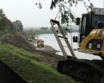 Rechts de graafmachine met een rek waarmee de plastic folie over de afgeschuinde oever wordt afgerold. (6-10-2009 - Jan Dolmans)