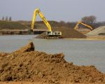 Op de achtergrond de dekgrondberging met het uitkijkpunt. De graafmachines kunnen nog wel effe vooruit. Dag in dag uit wordt de kiezel uit de diepte naar bovengehaald.   (17-3-2010 - Jan Dolmans)