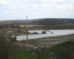 Veel bedrijvigheid in het Hartelsteinerveld. Er wordt grind uit de dekgrondberging gehaald, dekgrond verwijderd, dekgrond gestort en grind afgvoerd. (2-4-2010 - Han Hamakers)