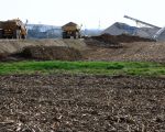 Dumpers rijden af en aan voor de aanleg van de werkweg. Op de achtergrond de verwerkingsinstallaties met het grinddepot.  (7-4-2010 - Jan Dolmans)