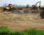 Op de achtergrond het gehucht Herbricht. De dekgrond die in de stroomgeulverbreding wordt afgegraven gaat met dumpers naar de dekgrondberging in het Hartelsteinerveld. (13-4-2010 - Jan Dolmans)