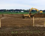 Aanleg van de dekgrondberging ten noorden van Borgharen. Na ontgrinding zal het ontstane gat weer gevuld worden met dekgrond die vrijkomt bij de stroomgeulverbreding. Op de achtergrond de huizen van Smeermaas, langs de Maas.  (12-5-2010 - Jan Dolmans)