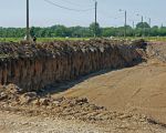 De fietsers links op de foto rijden nu nog over de oude weg, dit zal echter niet meer lang duren. Zodra de nieuwe weg gereed is zal de oude weg worden afgegraven.  (16-6-2010 - Jan Dolmans)