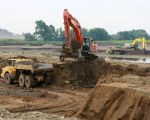 Op de voorgrond wordt de bocht in de Maas bij Herbricht, waar voorheen de weg liep, weggegraven terwijl aan de overkant de graafmachines aan Nederlandse zijde bezig zijn de stroomgeulverbreding te realiseren. Er tussendoor stroomt de Maas.  (29-6-2010 - Jan Dolmans)