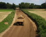 Voorlopig blijft het een kiezelweg die na verloop van tijd zal worden geasfalteerd. Dumpers rijden vanuit de locatie Borgharen kiezel om de werkweg aan te leggen.  (31-8-2010 - Jan Dolmans)