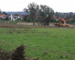 Graafmachine bezig met de weerdverlaging bij Hochter Bampd. Het weiland op de voorgrond zal enkele meters diep worden afgegraven. Achterdoor ziet u woningen van Itteren aan de overkant van de Maas.  (5-10-2010 - Jan Dolmans)