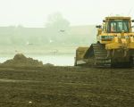 Vullen van de dekgrondberging met afgegraven grond vanuit de stroomgeulverbreding. Op de achtergrond Kasteelboerderij Hartelstein.  (12-10-2010 - Jan Dolmans)